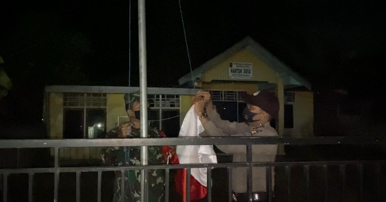 Babinsa dan Bhabinkamtibmas menurunkan bendera di Desa Lubuk Pendam pukul 22.10 WIB.