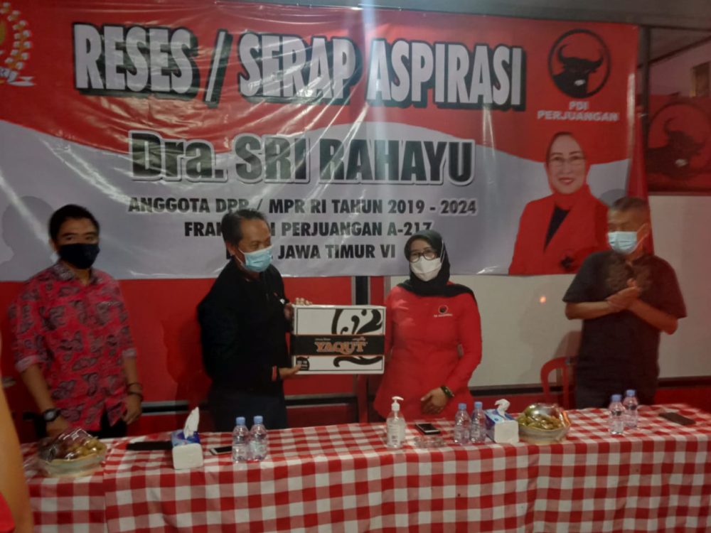 Anggota DPR RI, Dra Sri Rahayu saat menyerahkan bantuan secara simbolis, berupa Sarung kepada Bendahara DPC PDIP Kota Blitar, Said Nofandi